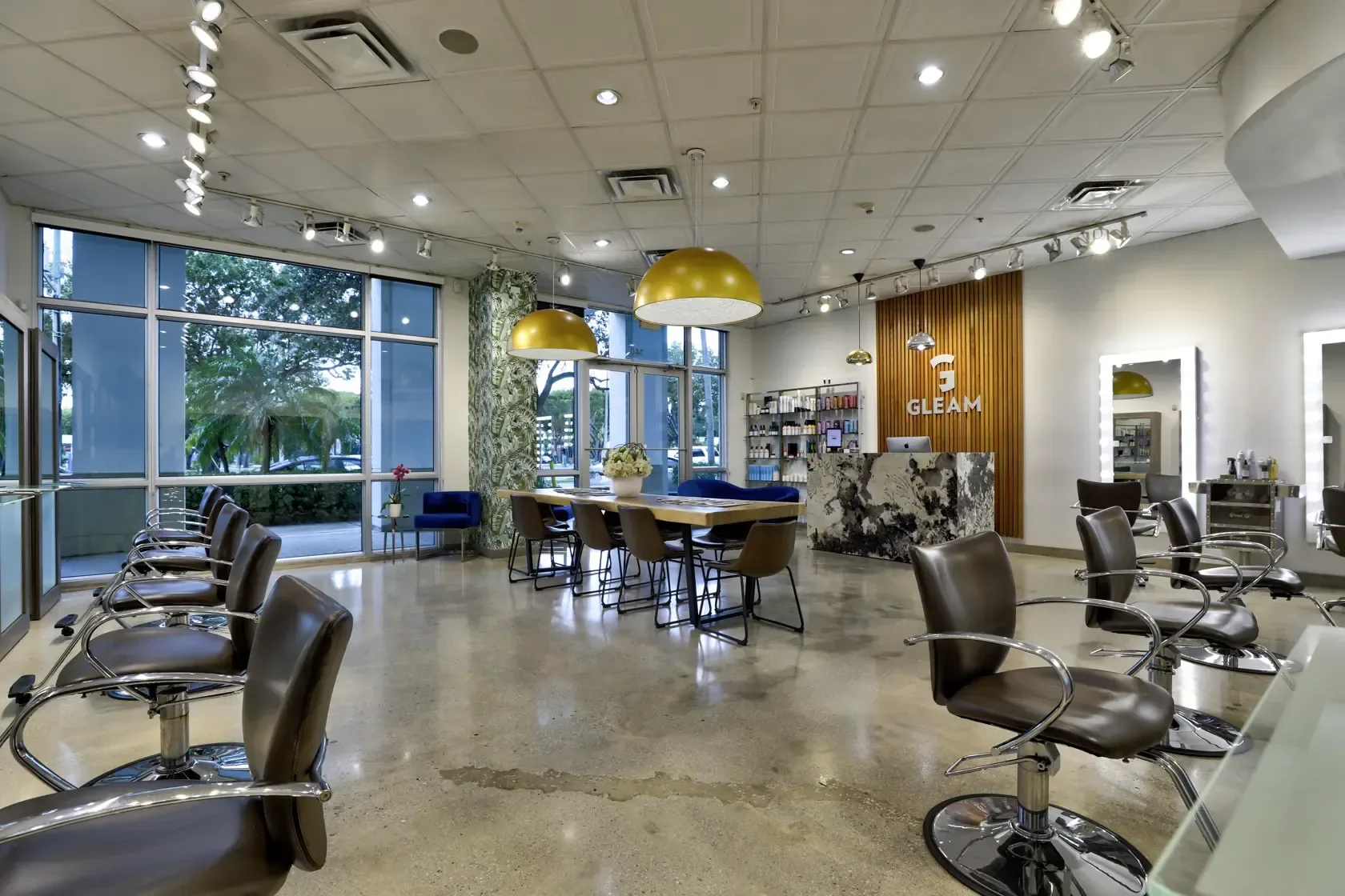 Interior of Gleam Hair Studio in South Miami, showing styling stations and worktables