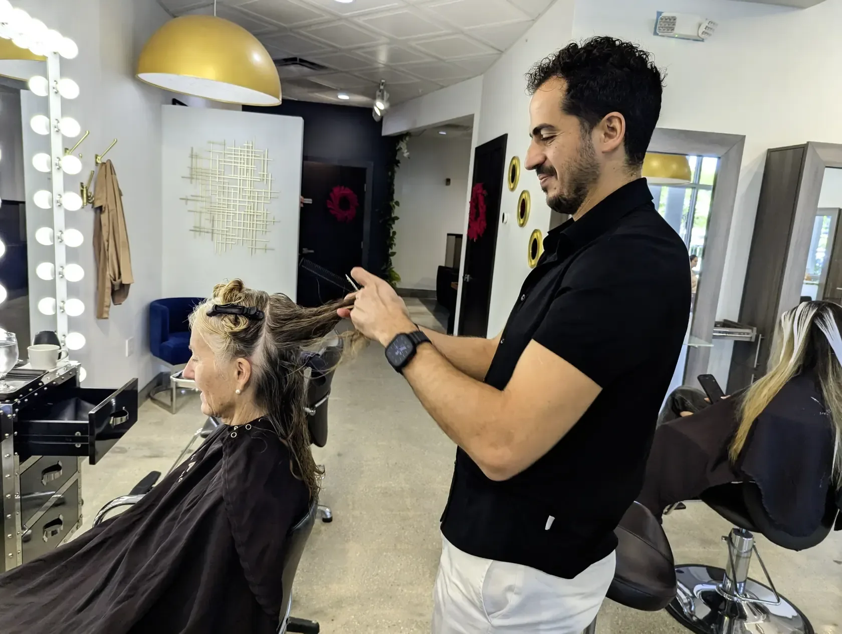 Gleam Hair Studio stylist working with a guest at a styling station